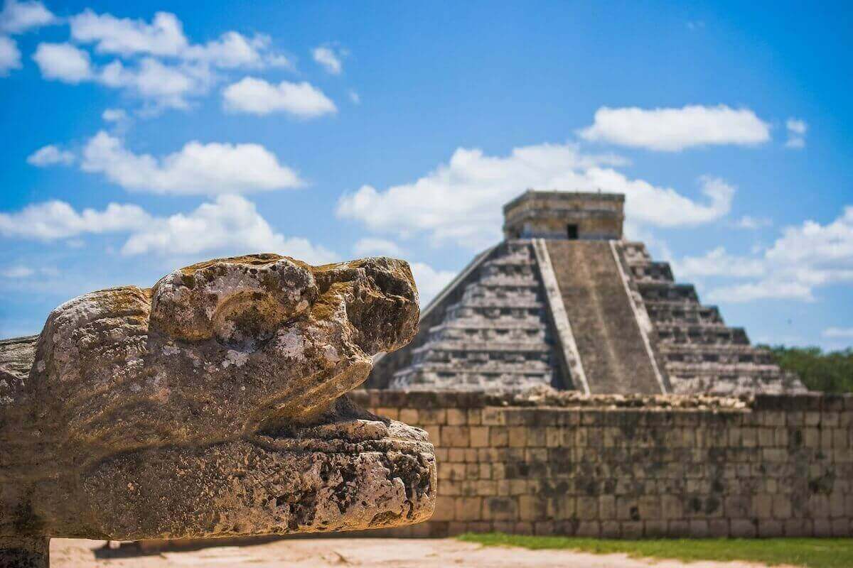 Tête de serpent en pierre devant la pyramide d'El Castillo à Chichén Itzá
