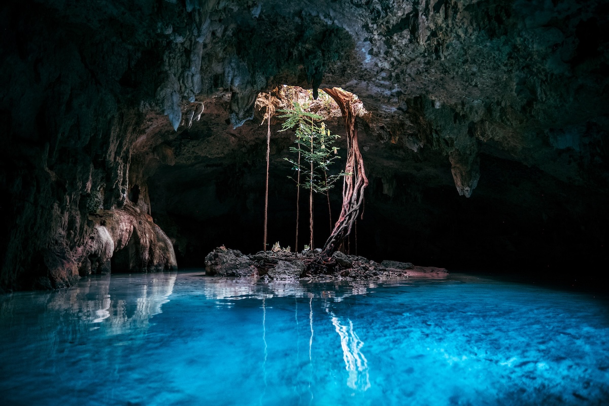Cenote-Höhle mit Tageslichtloch und türkisfarbenem Wasser in Mexiko