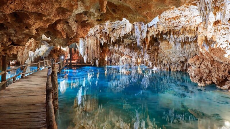 Cenote mit tuerkisblauem Wasser und Tropfsteinen beim Ausflug nach Coba und Tulum